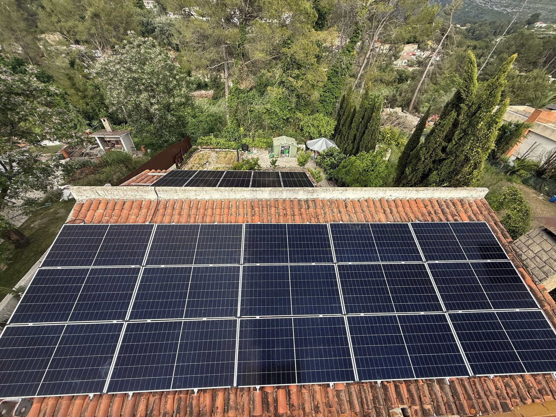 Vista aérea de una instalación sobre tejado de teja árabe, con el jardín de la vivienda abajo